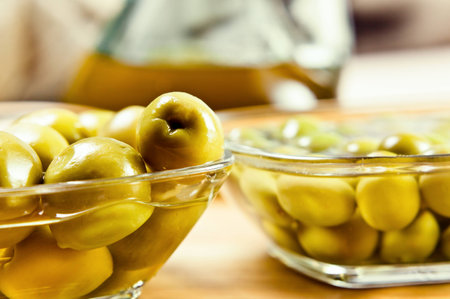 green olives on wooden table , focus on foregroundの写真素材
