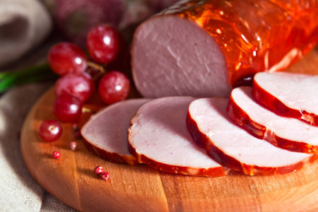 smoked meat and red grape on a wooden boardの写真素材