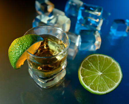 tequila , lime and ice on a glass table.の写真素材