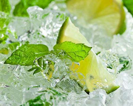 lime pieces and leaves of mint with iceの写真素材
