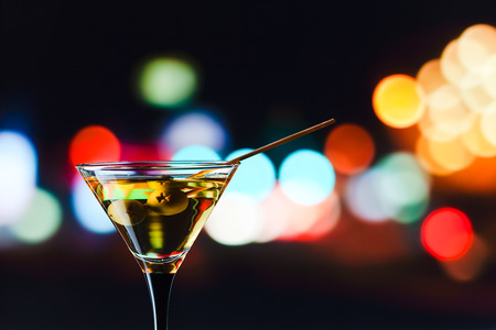 glass with martini , focus on a olivesの写真素材