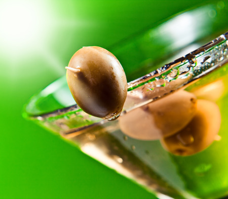 martini with green olives , focus on a foregroundの写真素材