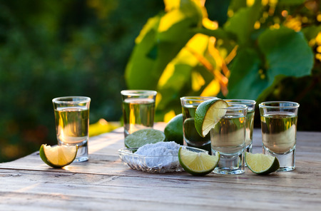 gold tequila with salt and lime on old wooden table.の写真素材