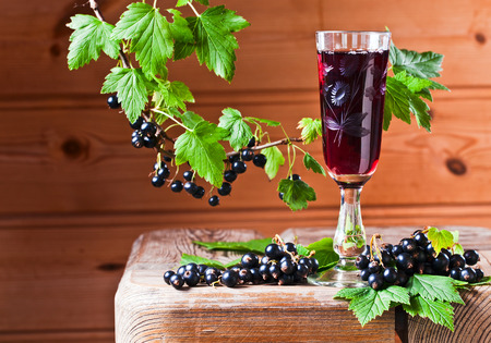 black currant liquor and ripe berries  on  wooden tableの写真素材