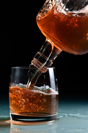 glass with whiskey and  on a glass table