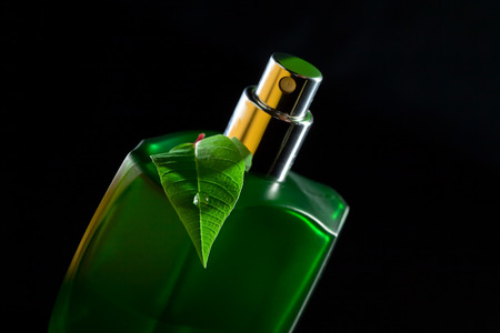 Green bottle with natural perfume on a black backgroundの写真素材