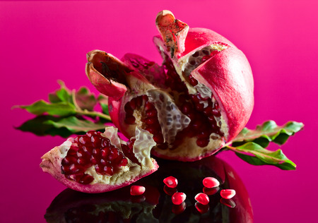 ripe pomegranate on a black glass table