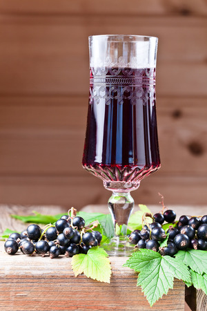 black currant liquor and ripe berries  on  wooden tableの写真素材