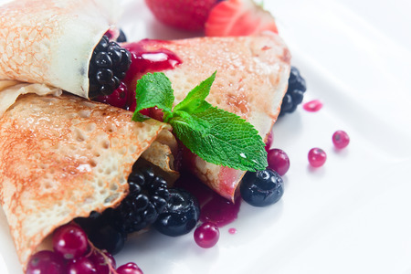 Pancakes with berries on a white plateの写真素材