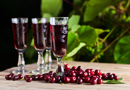 cherry brandy and ripe berries on  wooden tableの写真素材