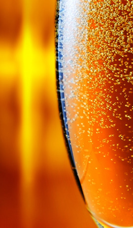 champagne in wineglass on a orange backgroundの写真素材