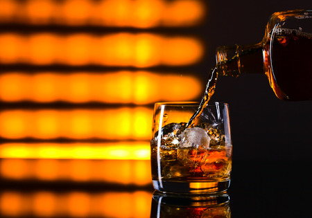 whiskey and ice on a glass tableの写真素材