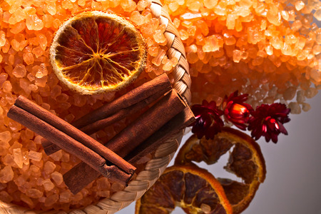 Sea salt with dried oranges and cinnamon sticks on glass table