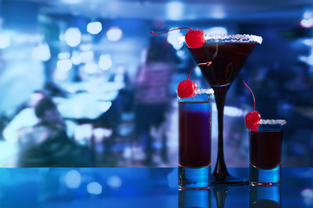 alcoholic drinks with sweet cherry on on glass table in barの写真素材