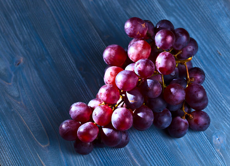 red  grapes on a old wooden table