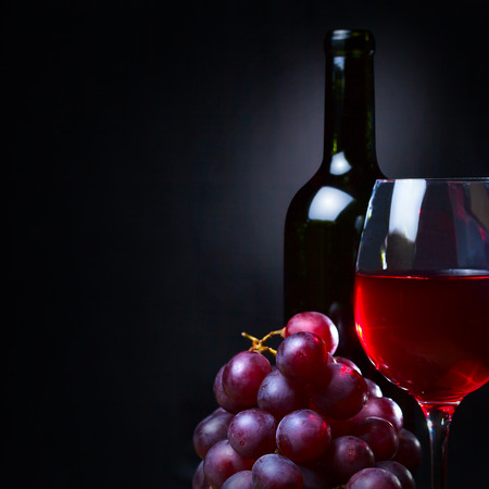 red wine and grapes on black backgroundの写真素材