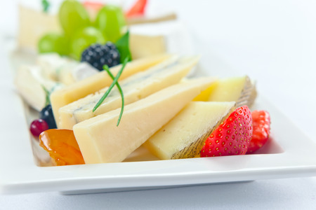 cheese with berries on a white plateの写真素材
