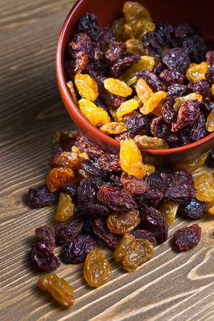 raisins in a brown dich on wooden tableの写真素材