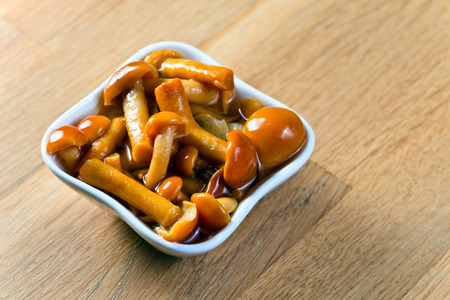 Marinated mushrooms  on a old wooden tableの写真素材