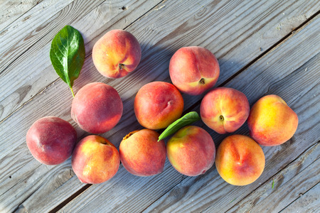 juicy peaches on wooden table in gardenの写真素材