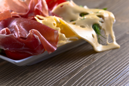 smoked meat and cheese on wooden tableの写真素材