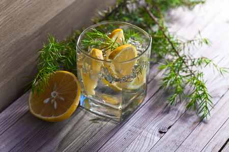 alcoholic drink with lemon and ice on a old wooden tableの写真素材
