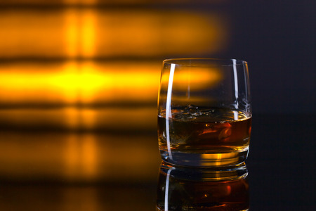 whiskey and ice on a glass tableの写真素材