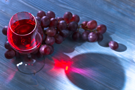 red wine and grape on old wooden tableの写真素材
