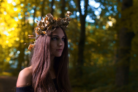 The young beautiful witch in dark forestの写真素材