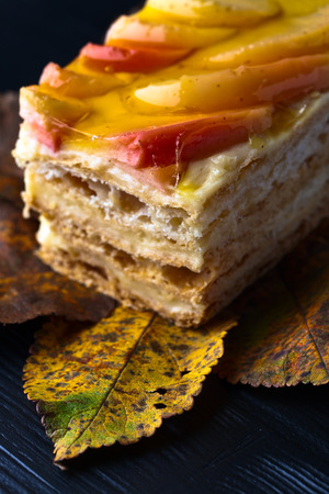 sweet pie with apples and jelly on a black wooden tableの写真素材