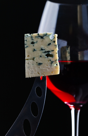 Gorgonzola and red wine on  black backgroundの写真素材
