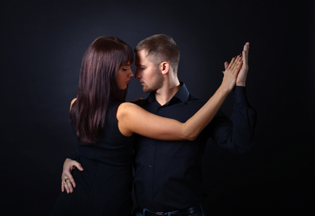 The young couple dancing on datk backgroundの写真素材