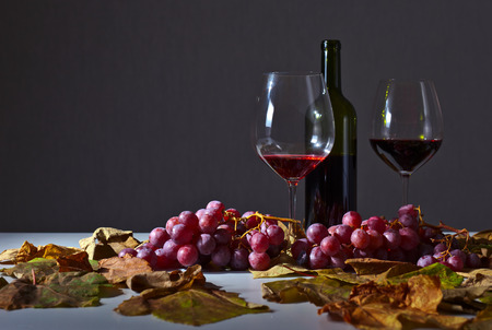 red wine with grapes and vine leavesの写真素材