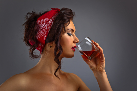 portrait of young beautiful woman with whiskeyの写真素材