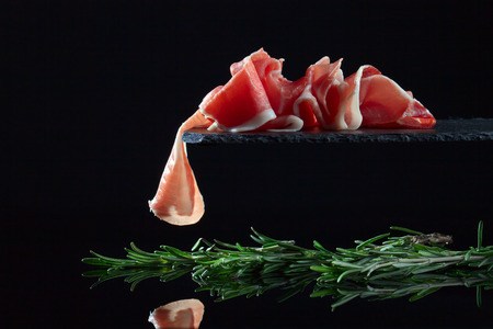 jamon with rosemary on  a black backgroundの写真素材
