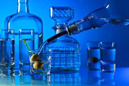 vodka with green olives in bar on a glass table in barの写真素材