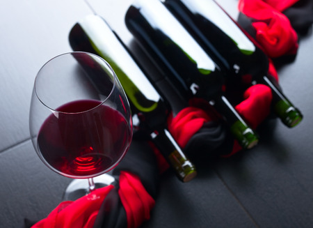bottles and glass of red wine on  black tableの写真素材