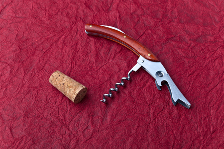corkscrew and cork on a red backgroundの写真素材