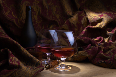 Two glasses of brandy on a wooden tableの写真素材