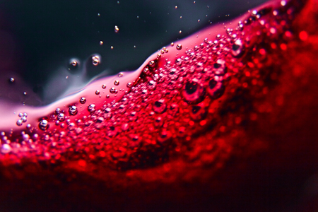 Red wine on black background, abstract splashing.の写真素材