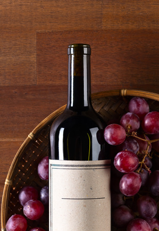 The bottle of red wine on old wooden tableの写真素材