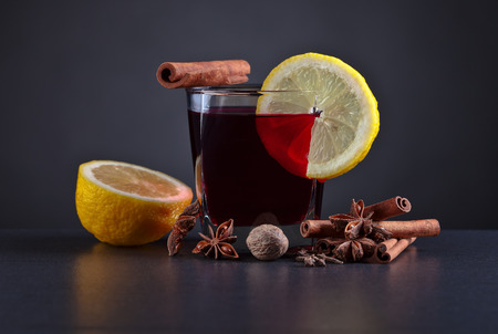 Mulled wine with spices on a black tableの写真素材