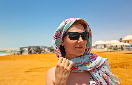 Middle age woman on a beach of dead seaの写真素材