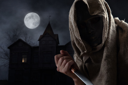 The hooded man in mask with a big knifeの写真素材