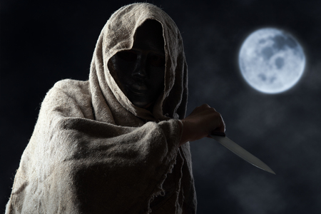 The hooded man in mask with a big knifeの写真素材