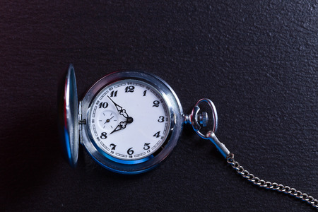old pocket clock on a black table