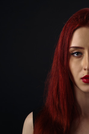 sad red-haired woman in a black dressの写真素材