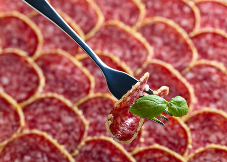 Salami sausage slices and green basil , selective focusの写真素材