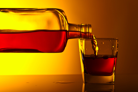 bottle and glass of whiskey on a glass table in barの写真素材