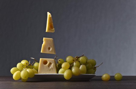 Cheese with grape on a old wooden tableの写真素材